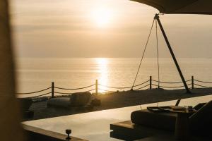 a view of the ocean with the sun setting over the ocean at Our Habitas Ras Abrouq in Dukhān