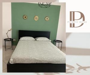 una camera con letto e testiera nera di DP Pompei Home a Pompei