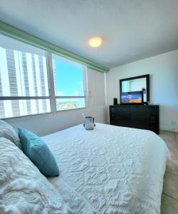 マイアミビーチにあるBeachfront Property Pool Gym Tennis Miami Beach!のベッドルーム(白い大型ベッド1台、テレビ付)