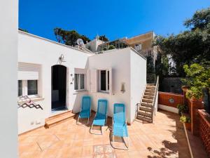 a patio with two blue chairs and a staircase at Casa Francesca - Immobilevante in Ponza