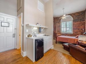 a kitchen and living room with a couch and a bed at The Front Street Inn in Wilmington