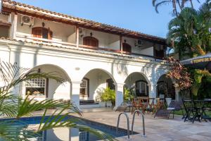 a building with a swimming pool in front of it at Pousada Boulevard in Cabo Frio