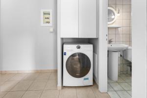 a washing machine in a bathroom with a sink at Abatis CityHome in Lefkada