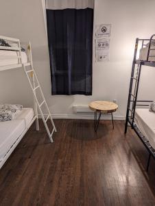 a room with two bunk beds and a table at The Parkdale Hostellerie in Toronto