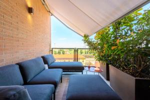 a living room with blue couches and a brick wall at Tiny House Tower in Fidenza
