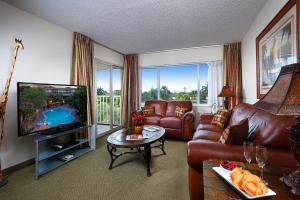 a living room with leather furniture and a flat screen tv at Best Western Naples Inn & Suites in Naples