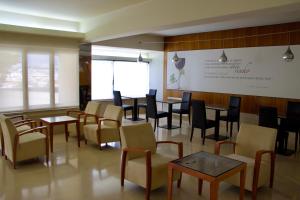 a waiting room with tables and chairs and a screen at Hotel Eurosol Leiria & Jardim in Leiria