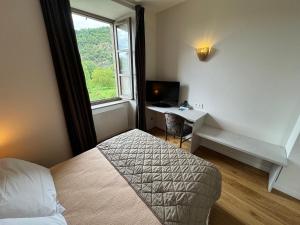 TV a/nebo společenská místnost v ubytování Logis Hôtels - Hostellerie des Lauriers - Hôtel et Restaurant
