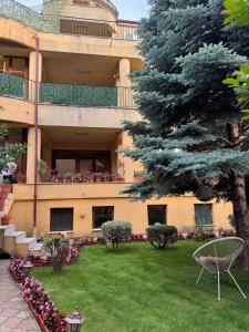 a large building with a green yard with a tree at Apartament Central in Constanţa
