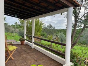 a wooden deck with a pergola and a bench at Moinhos do Paneiro in Santiago do Cacém