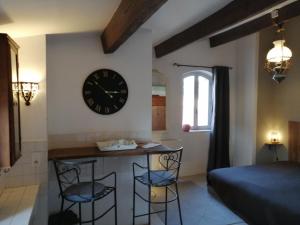 a room with a clock on the wall and two bar stools at Le Perchoir in Mérindol +11 photos