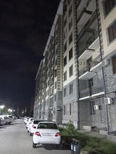 een rij auto's geparkeerd voor een gebouw bij Elet Haus 197 in Sergeli