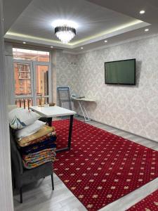 een woonkamer met een tafel en een rood tapijt bij Elet Haus 197 in Sergeli