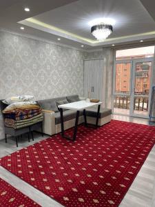 een woonkamer met een bank en een tafel op een rood tapijt bij Elet Haus 197 in Sergeli