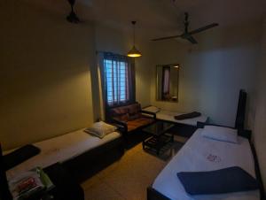 a room with two beds and a chair and a mirror at Hotel Hoque Tower International in Chittagong