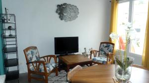 a living room with a table and a television at FLOREVA 22 entre Plage et Thalasso - Internet fibre in Concarneau