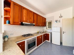 a kitchen with wooden cabinets and a white refrigerator at Casa Francesca - Immobilevante in Ponza