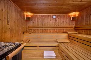 a wooden sauna with benches and a towel in it at Courtyard by Marriott Magdeburg in Barleben