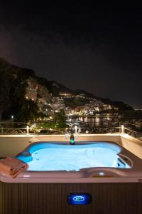 a jacuzzi tub on a balcony at night at Hotel Aurora in Amalfi