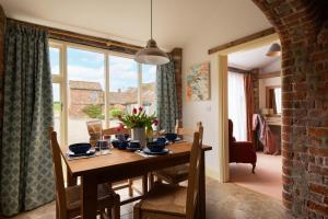 Un comedor con una mesa de madera y una ventana. en The Roost, Heritage Escapes, Field House Farm, en Bempton
