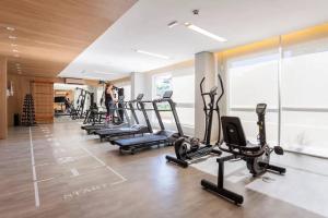 einen Fitnessraum mit Laufbändern und Kardiogeräten in der Unterkunft Terraço, Aconchegante, Gym, Ar, WiFi, PUCRS, Pet in Porto Alegre