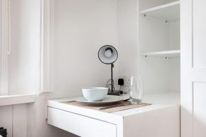 a white kitchen with a bowl on a table at Fabulous Studio in Paddington - 22 in London