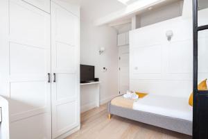a bedroom with white walls and a bed and a tv at Fabulous Studio in Paddington - 22 in London