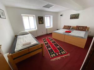 a bedroom with two beds and a rug at Apartman ''Trg'' in Tuzla