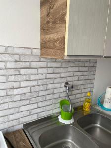 a kitchen sink with a green cup and a faucet at Apartman ''Trg'' in Tuzla +16 photos