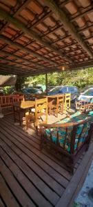 a wooden deck with a table and chairs on it at Pousada Prumirim Surf Suítes in Ubatuba