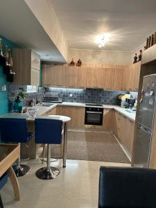 duża kuchnia z drewnianymi szafkami i niebieskimi urządzeniami w obiekcie ZEN Neapoli Penthouse Apartment w Atenach