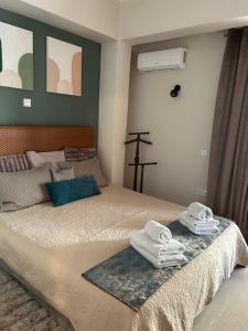 sypialnia z łóżkiem i ręcznikami w obiekcie ZEN Neapoli Penthouse Apartment w Atenach