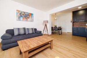 a living room with a blue couch and a table at Apartmani Viktorija in Jadranovo