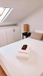 孔波尔塔GuestReady - Seaside Serenity in Comporta的一张带毛巾的白色床和遥控器