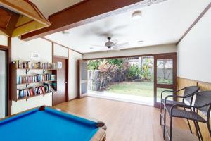een woonkamer met een pooltafel en een boekenplank bij White Sands Resort #108 in Kailua-Kona