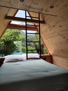 a bed in a room with a large window at Baita Eleonora in Argegno +129 photos