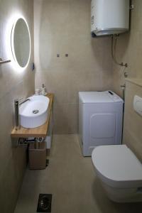 a bathroom with a white toilet and a sink at Family House Bubalo in Opuzen +34 photos