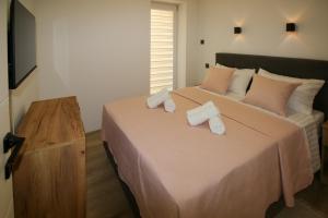 a bedroom with a large bed with two towels on it at Family House Bubalo in Opuzen