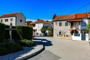 a cross on the side of a street with houses at Family House Bubalo in Opuzen