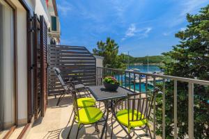 a patio with a table and chairs on a balcony at Apartmani Viktorija in Jadranovo