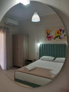 a bedroom with a bed and a mirror at NIKOS DIMAS STUDIOS in Parga