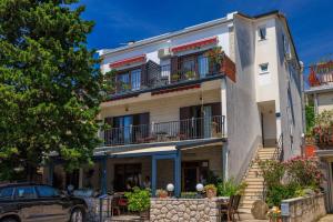 a building with a car parked in front of it at Apartmani Viktorija in Jadranovo