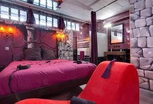 una camera con letto rosa e sedia rossa di Chambre Marquis de Sade a Vichy