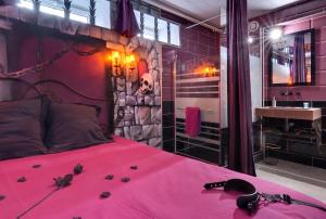 una camera con letto rosa e lavandino di Chambre Marquis de Sade a Vichy