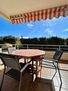 a wooden table and two chairs on a patio at Eden B7 Appartement in Saint-Tropez +22 photos