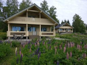 a house with a field of purple flowers at Loghouse in Hjorto in Ödkarby