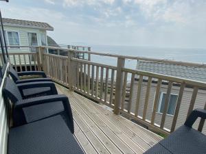 a balcony with chairs and a view of the ocean at Static Caravan at Lydstep Beach in Tenby