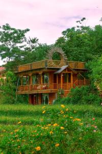 a wooden house with a large deck in a field at Pu Luong Jungle Lodge in Pu Luong +286 photos