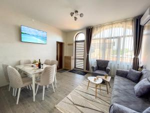 a living room with a table and a couch at КЪЩА ЗА ГОСТИ ГРОШЪ in Dobrinishte