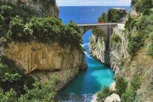 a train on a bridge over a river at Domus Julia in Furore
